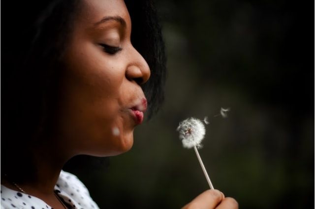 Woman blowing on dandelion, Therapy for Life LLC